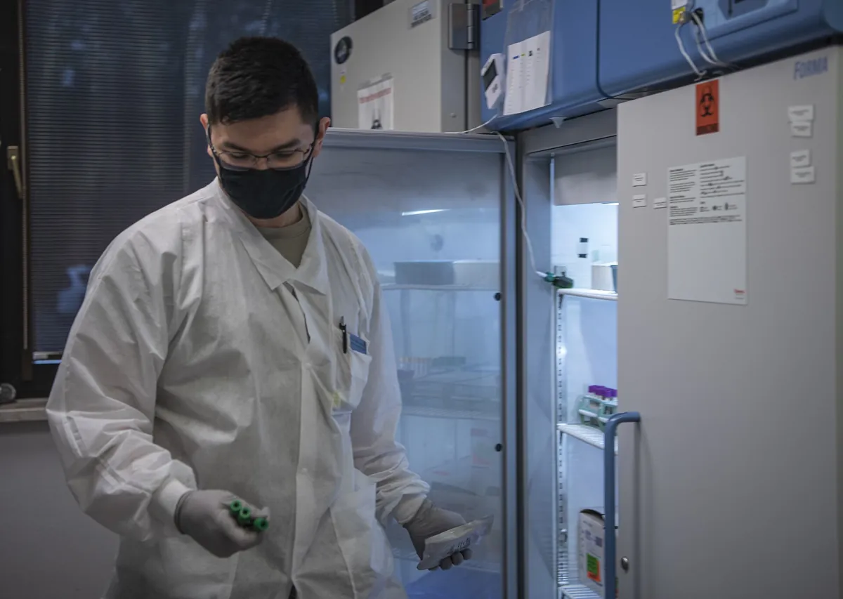 A researcher at an open laboratory refrigerator